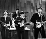 Vintage black and white photo of The Beatles performing live music at a studio