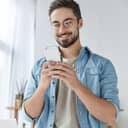 A young smiling man reading a message on a phone