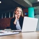 young businesswoman reading positive feedback on her laptop while working in the office