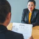 Human resource manager conducting job interview with a smiling female candidate in a meeting room.