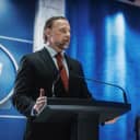 government spokesperson delivering a speech at a press conference in a government building