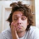 A man with a messy hair looking himself in the mirror