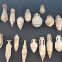 Roman terracotta pots exhibited against a black wall in a museum showcasing Roman artifacts in Xàbia, Spain.