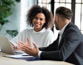 Two people in business setting amicably conversing