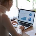 A woman looking at data on laptop
