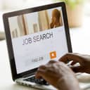 A closeup of a person looking for a job using a laptop
