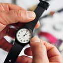 a man adjusting the time on his black analog watch