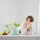 Asian middle-aged woman looking nauseous in a modern kitchen setting