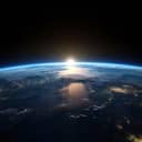Sunrise view of the planet Earth from space with the sun setting over the horizon