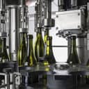 an industrial machine fills bottles with wine for distribution in a Sicilian wine factory in Italy