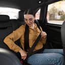 young woman fastening the seatbelt in the back seat of the car