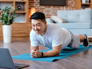 A middle aged man doing a plank exercise at home