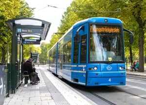 Tram in traffic on road in center of Stockholm.