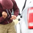 Thief trying to break into a parked car