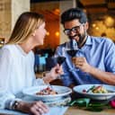 happy couple on a romantic date eating pasta and drinking red wine at a restaurant