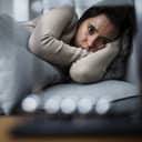 Apathetic young woman lying in bed