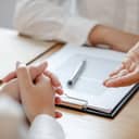 lawyer discussing a legal matter with a client at his law firm, close-up on their hands