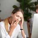 close-up of a businesswoman yawning at her desk in the office