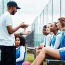 A netball coach outlines game strategies to the team, emphasizing teamwork and collaboration.