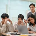 Upset coworkers sitting around a laptop