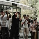 A big group of paparazzi gathered in front of a building, with their cameras ready.