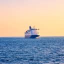 cruise ship traveling across the North Sea during sunset