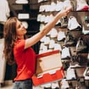 young woman putting a shoe on a shelf in a sportswear shop