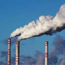 Thick white smoke coming out of two out of three industrial chimneys