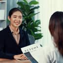 Female recruiter interviewing one candidate, discussing her CV and application during a job interview.
