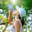 A young woman drinking water from a bottle outside