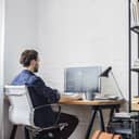 young man working at his computer in a home office setup