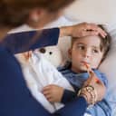 Woman taking a small boy's temperature orally