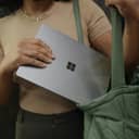 close-up of a woman placing her Surface laptop into her green bag