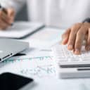 close-up of a bookkeeper managing finances and calculations with the help of a calculator.