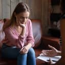 Depressed young woman listening to an African American therapist during a counseling session
