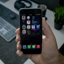 close-up of a person's hand holding a black iPhone 6s