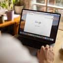 Person looking at the Google starting page displayed on laptop monitor