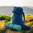 A hiking backpack equipped with a mat, essential gear for a mountain trek and camping expedition.
