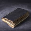 vintage notebook closed with worn pages on a wooden textured background