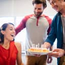 Three team members in an office celebrating a colleague's birthday.