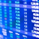 close-up of a stock market quote display reflecting a cityscape on LED glass