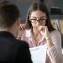 Stressed young female applicant feeling nervous at job interview while hr reading resume, unprepared candidate worried biting nails afraid of bad result at hiring negotiations, fear of fail concept