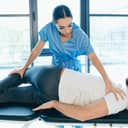 Close-up of a man receiving treatment for his lumbar disc, while his physiotherapist performs specialized exercises for alleviating sciatica.