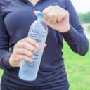 A woman holding a plastic bottle filled with water