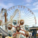 An amusement park with a roller coaster and a ferris wheel