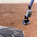 NASA's Phoenix Mars Lander captured with its solar panel and Robotic Arm holding a soil sample on Martian Sol 16, 2008.