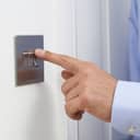 A close-up shot of a man's hand turning off a light switch.