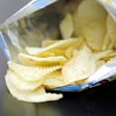 open bag of potato chips on a black table