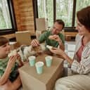 A family moving into new house and enjoying lunch with makeshift table.