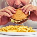 A man eating hamburger and fries